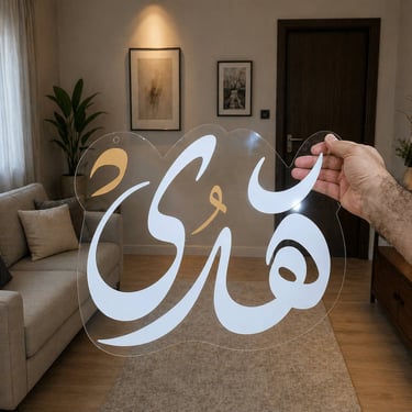 لوحة أكريليك شفافة مخصصة مكتوب عليها اسم هدى بخط عربي جميل وألوان أبيض وذهبي في ديكور منزل عصري