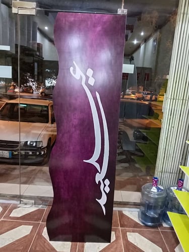 لوحة فلين بنفسجية متموجة مع خط عربي أبيض متقن