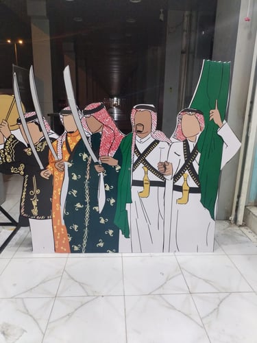 مجسم فلين يمثل رجالاً بالزي الشعبي السعودي التقليدي يحملون السيوف والعلم السعودي مخصص للتصوير في ف