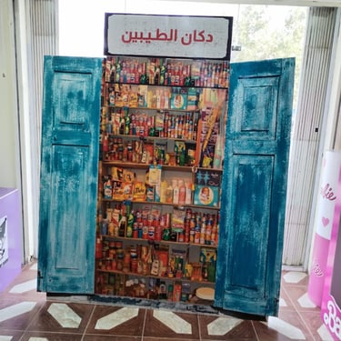 واجهة دكان الطيبين التراثية بداخلها أرفف مليئة بمنتجات قديمة مثل صابون تايد وعلب مشروبات غازية كلاسي