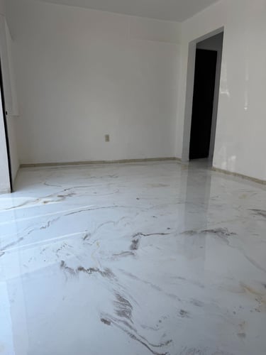 Modern interior featuring a glossy white marble-effect epoxy resin floor in an empty room.