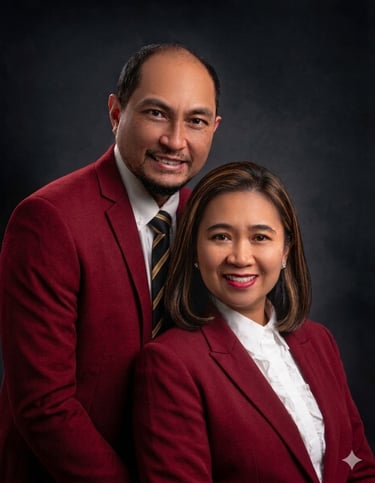 Professional portrait of a man and woman in matching maroon blazers for a corporate business headshot.