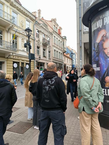 Gidė Ramutė pasakoja istorijas ekskursijos dalyvių grupei Vilniaus senamiestyje, Pilies gatvėje.