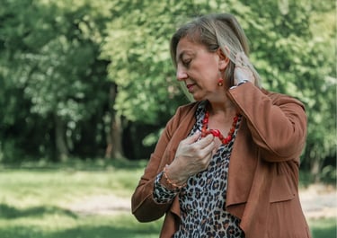Donna che indossa collana rossa in un gesto naturale – fotografia materica ed emozionale realizzata da Gaudife a Bologna.