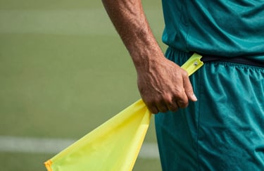 Close-up of a hand pulling a yellow flag from a player's belt during a fast-paced game, professional teal jersey visible.