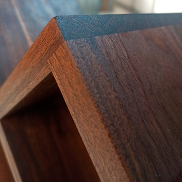 Close-up of precise joinery detail on handcrafted American walnut wine rack