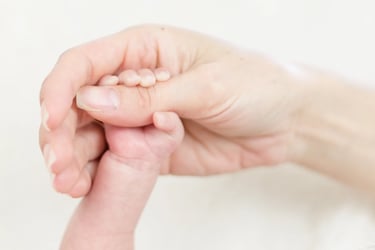 Die Hand einer Frau hält die Hand eines Babys.