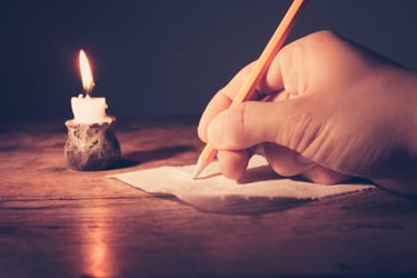 Hand writing notes beside a candlelight during a paranormal assessment and spiritual consultation