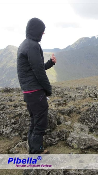 Female hiker in rainy weather with Pibella Travel device, giving thumbs up