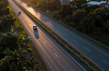 An aerial shot of a multi-lane highway in Brazil at sunset, with car headlights creating golden and Soft Ice Blue trails.