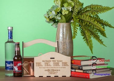 Lifestyle display featuring a custom wooden box for carrying smaller products. Set includes green background with books.