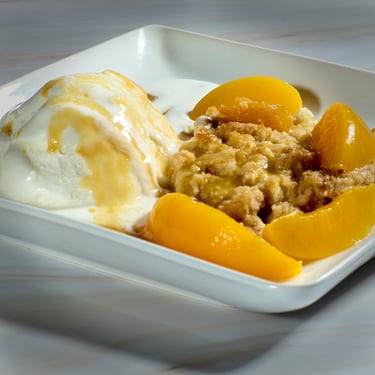 Peach Cobbler and a scoop of vanilla Ice cream with  Peach Puree Topping, and Sliced Peaches.. # Food Photography,  