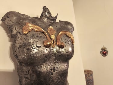 sculpture poitrine de femme en metal avec volutes à la feuille d'or dans salon avec motif deco de coeur rouge