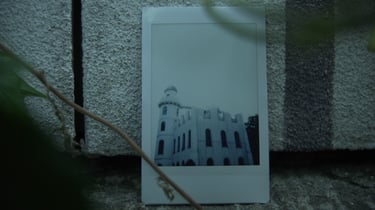 Photograph of a white castle placed against a stone wall, still from Nostalgia by Tina Bikic.