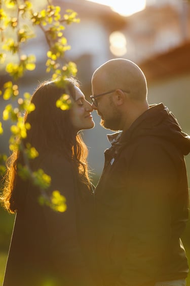 Lui e lei vicinissimi, le punte dei loro nasi si toccano, illuminati da una luce dolce del tramonto 