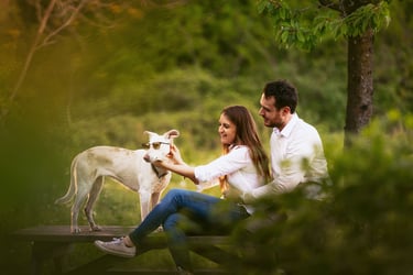 La coppia di futuri sposi posa insieme al loro cane. La sposa fa indossare i suoi occhiali al cucciolo