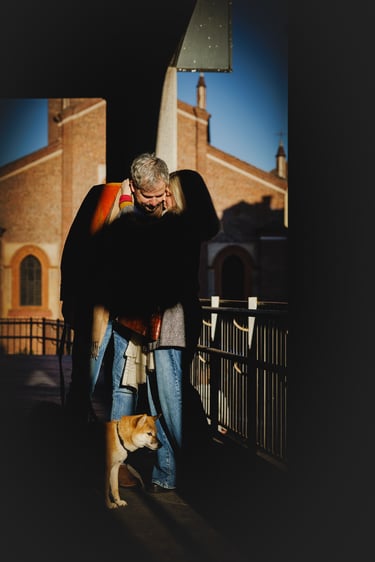 Una coppia si abbraccia dolcemente nella città di Lodi iin compagnia del loro cane al guinzaglio