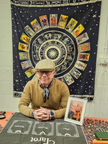 Rob hamilton 4th generation Romani reader, sitting down, astrological signs behind him