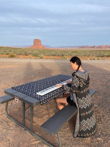 Composer Jen Smith Lanthier playing a keyboard in the Arizona desert