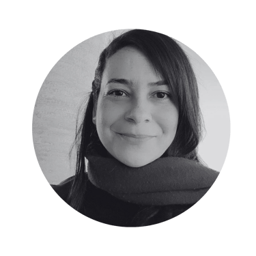 Black and white portrait of a smiling woman in a circular frame wearing a winter scarf.