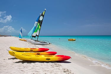 Colorful kayaks and a small catamaran sailboat on the white sands of Bai Dai Beach in Cam Ranh