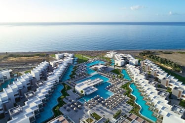 Aerial view of a luxury beachfront resort with private swimming pools and modern architecture.