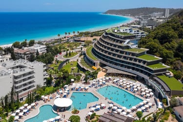 Luxury beach resort in Rhodes with outdoor swimming pools and tiered architecture overlooking the Aegean Sea.