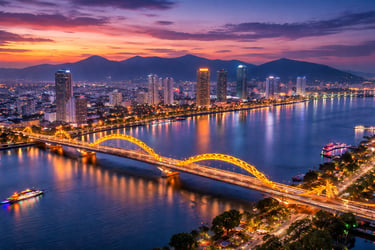 This image shows a stunning twilight view of Da Nang with the glowing Dragon Bridge stretching acros