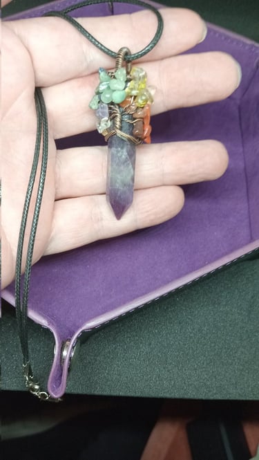 a purple crystal with fruit ornaments at the top of the crystal