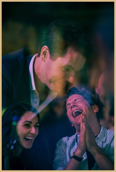 Maxwell Pritchard performs magic as audience members laugh and applaud.