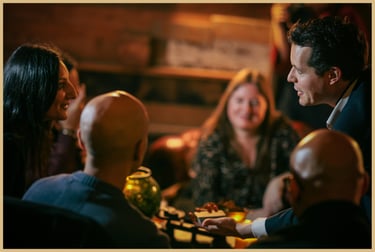 Maxwell Pritchard performing magic as audience members look on, engaged.