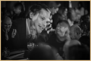 A happy audience claps and laughs as Maxwell Pritchard performs magic.