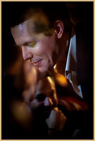 An abstract portrait of Maxwell Pritchard performing magic as audience members smile.