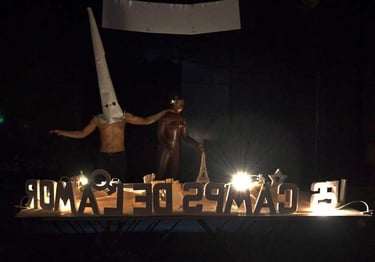 David portant la coiffe pointue du KKK tient une poupée noire | Les Camps de l'Amor | David Noir | Photo Karine Lhémon