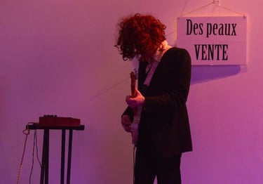 Christophe Imbs à la guitare devant une pancarte "Des peaux vente" | Les Camps de l'Amor | David Noir | Photo Karine Lhémon