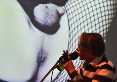 David au micro devant une projection de son cul | Les Camps de l'Amor | David Noir | Photo Karine Lhémon