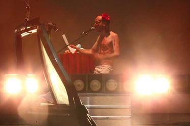 Adrien coiffé en petite fille, au micro derrière la portière de voiture | Mobil'Homme | David Noir | Photo Bernard Bousquet