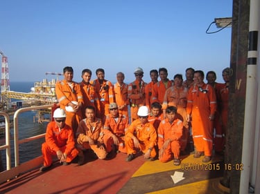 Oil rig workers posing for a group photo on an offshore platform.