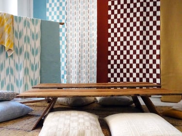 Scénographie avec des soies japonaises et des tissus d’Aïssa Dione pour une mise en scène textile unique.