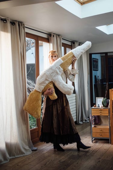 Œuvre d’art unique : coussin en forme de kalachnikov, réalisé en matériaux upcyclés pour une approche engagée.