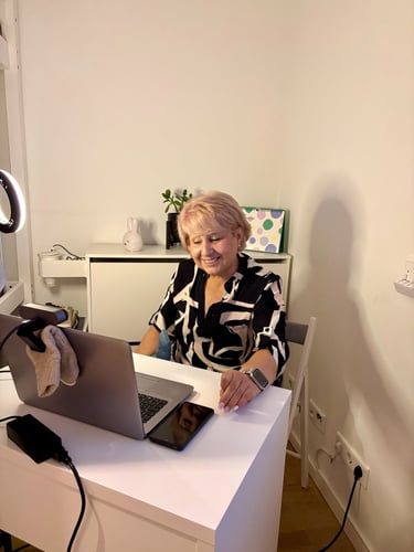 Profe Cris working on a laptop having a 1 2 1 meeting with a mom and her baby.