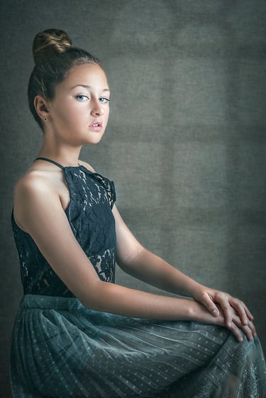 a girl with a high head bun posing for the camera in a photography studio in Sydney