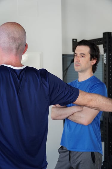 A personal trainer instructs a male client during a workout session in a modern home gym.