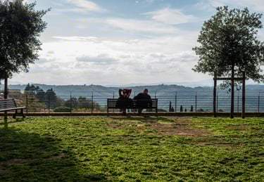 Two people talking on a public chair enjoying the view