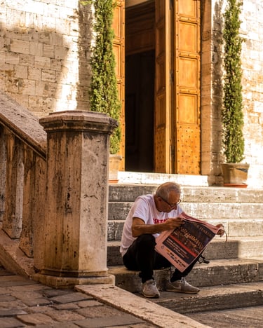 Man sitting on steps reading newspaper 