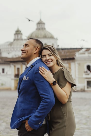 Fotografía de bodas en Quito, Ecuador, pareja de recién casados dándose abrazo plaza de San Francisco sonriendo a cámara