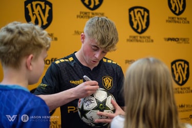 Jack Thomas (Fort Wayne Football Club) autographs a ball for young fans