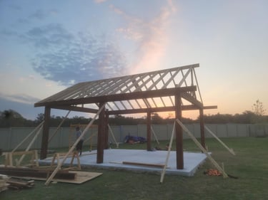Wood pavilion under construction at sunset.