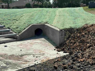 Concrete drainage culvert with erosion control matting.
