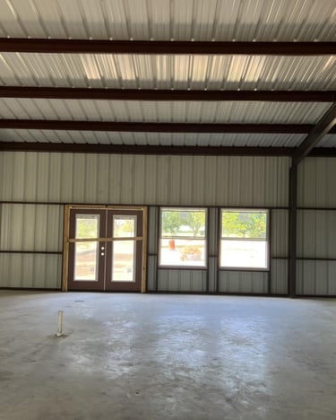 Interior of metal shed with doors and concrete floor.